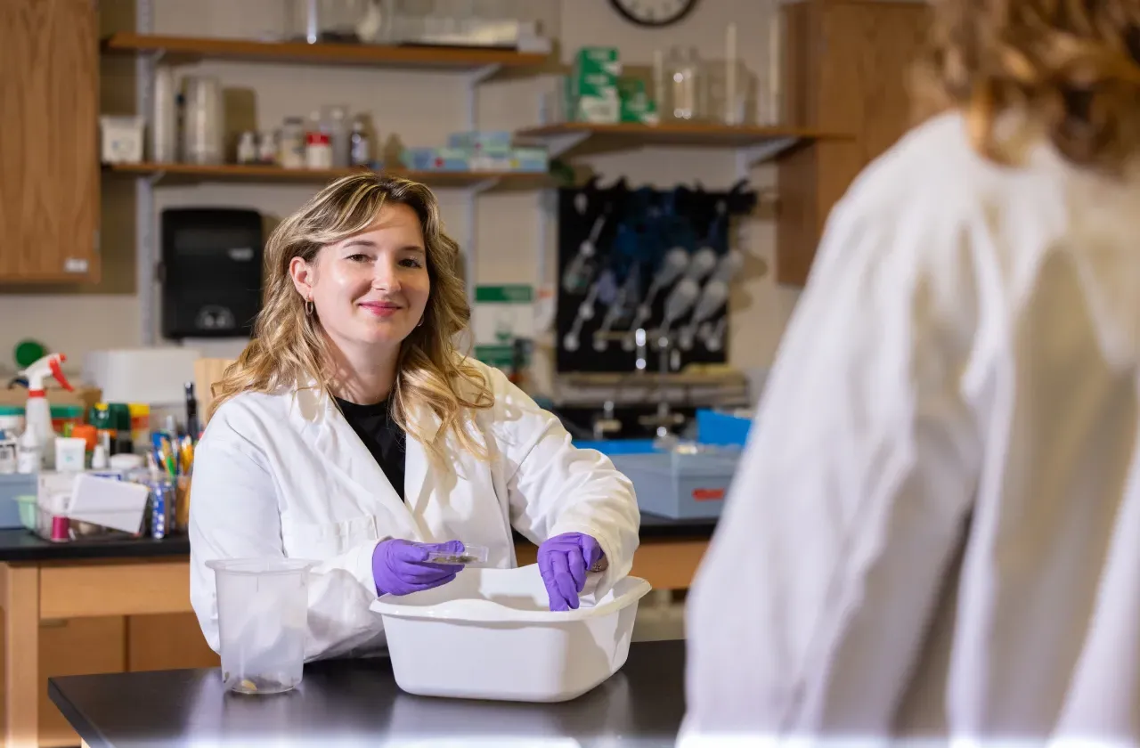 A student in a lab coat in Professor Marney Pratt's lab